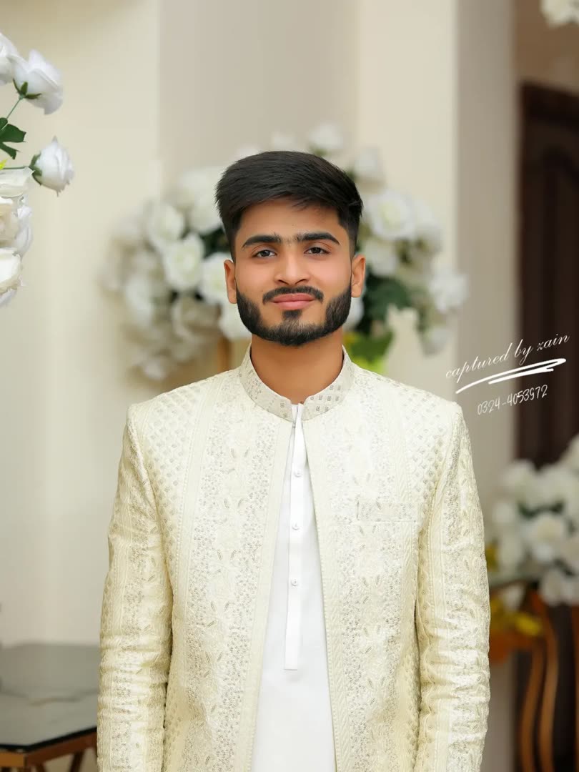 Talha in a white sherwani